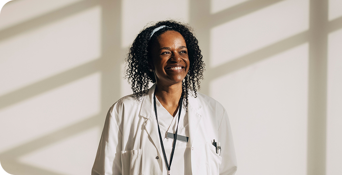Smiling female doctor contributing to cancer news and advancements in healthcare.