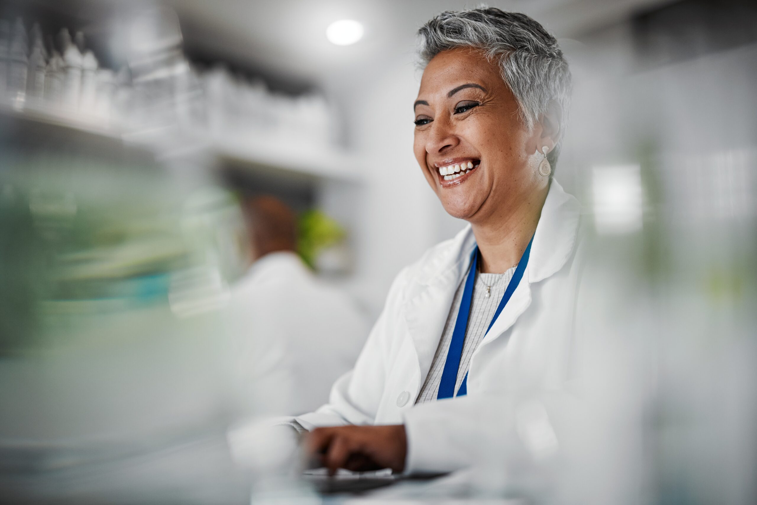 Smiling professional in a lab coat, embodying success through BeOne Careers.
