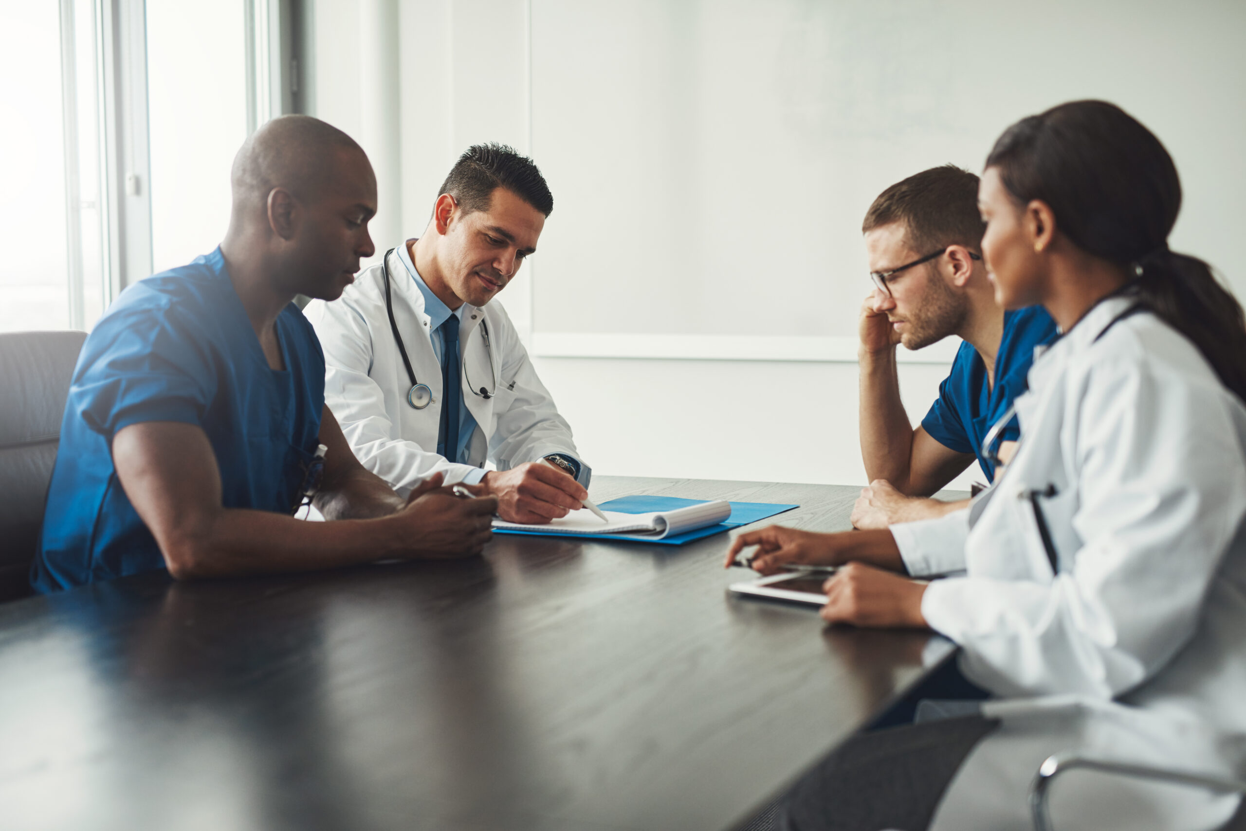 Four people sit around a table discussing data privacy awareness in the context of cancer care.